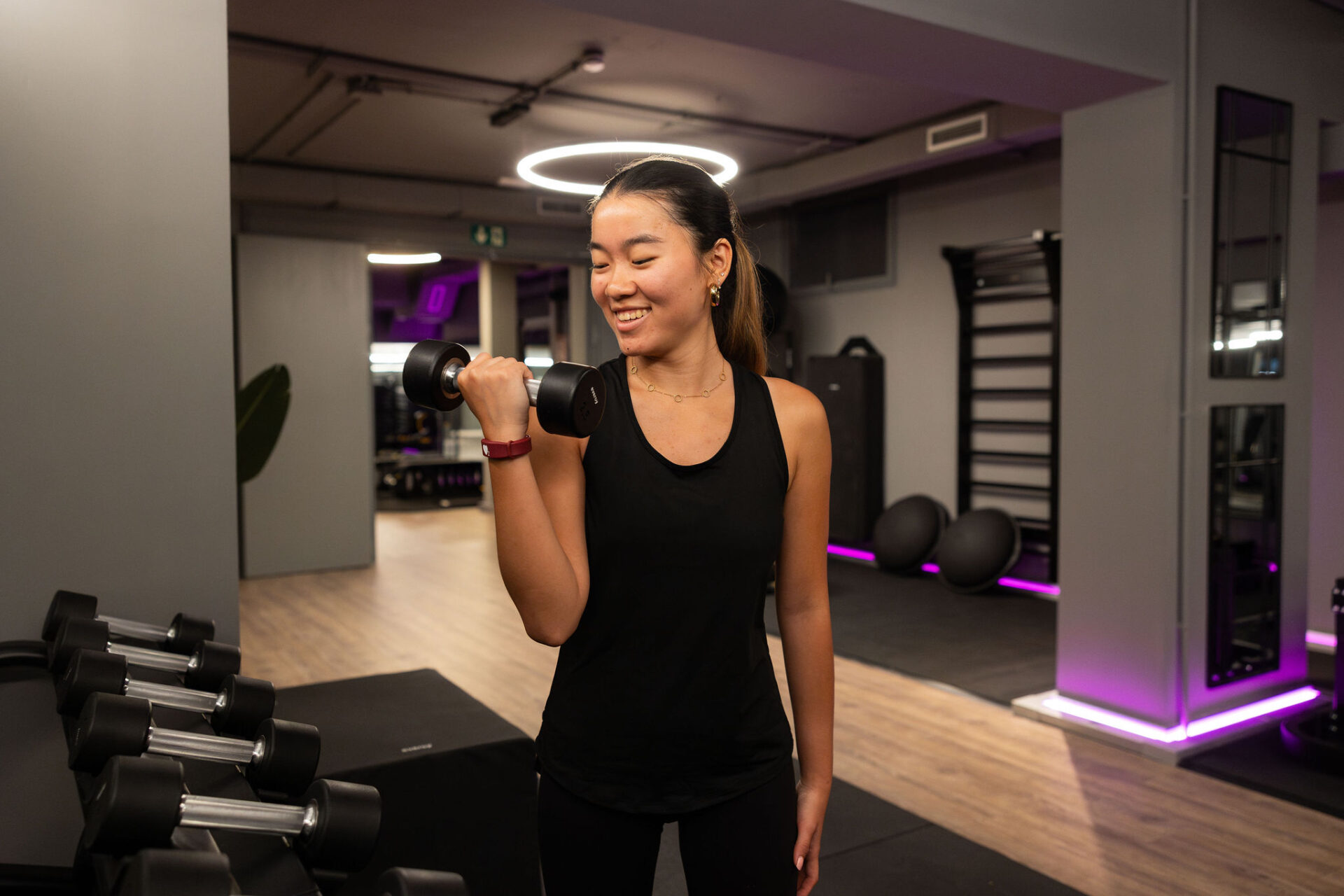 Mujer haciendo entrenamiento de fuerza con mancuernas en el gimnasio